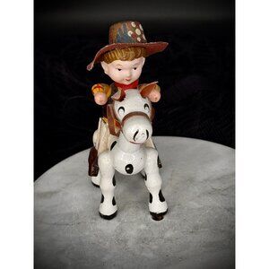 Vintage hand-painted and features a boy cowboy riding a spotted horse